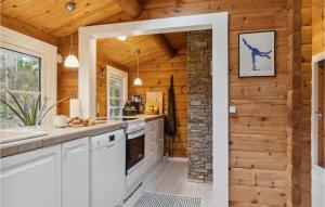 a kitchen with white cabinets and a brick wall at 3 Bedroom Beautiful Home In Hornbæk in Hornbæk