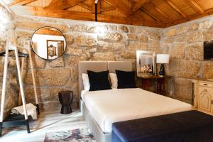 a bedroom with a bed in a stone wall at Refúgios da Natureza in Entre -os- Rios