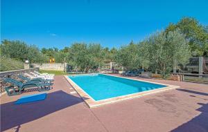 ein großes Schwimmbad mit Liegen in der Unterkunft 4 Bedroom Amazing Home In Pavicini in Veliki Vareški + 33 Fotos