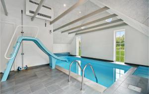an indoor swimming pool with a blue slide in a house at Beautiful Home In Ulfborg With Sauna in Øby +24 photos
