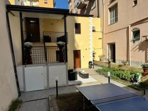 un patio con mesa y pista de tenis en Villa Ebe - Casa indipendente con giardino, en Torre Annunziata