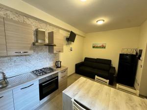 cocina y sala de estar con sofá. en Villa Ebe - Casa indipendente con giardino, en Torre Annunziata