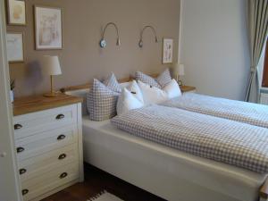 a bedroom with a bed and a dresser with pillows at Schöne Ferienwohnung im Nationalpark nördlicher Schwarzwald in Forbach