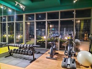 a gym with rows of exercise equipment in front of a window at Riveria City at KL Sentral by KKT in Kuala Lumpur