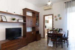 a living room with a television and a dining room table at Alice Apartments in Rho