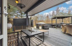 un patio con tavolo e sedie su un ponte di Cozy Home In Ålbæk With Kitchen ad Ålbæk