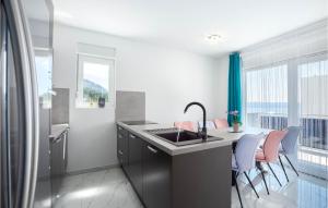 a kitchen with a sink and a table with chairs at Beautiful Apartment In Podstrana in Podstrana