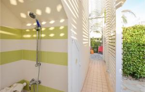 ein Badezimmer mit grün-weißen Wänden und einer Dusche in der Unterkunft Cozy Home In Marina Di Ragusa With Wifi in Marina di Ragusa + 17 Fotos