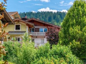 een huis met een balkon midden tussen de bomen bij Rosenberger I und II in Hopfgarten im Brixental