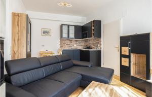 上瓦特Arkadenhaus Apartment Klein的一间带黑色沙发的客厅和一间厨房
