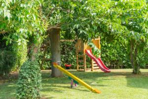 a playground with two slides and a tree at Podere Casalpiano Campiglia Marittima BARATTI POPULONIA Bella Tuscany in Casa Banditelle