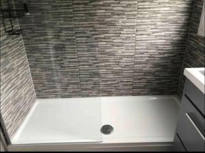 a bathroom with a shower with a white tub at Coombe Corner Cornwall in Bude