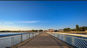 a bridge over the water on a beach at Cocon avec spa in Mios