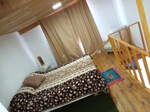 a bedroom with a bed and a wooden staircase at El Campito in Necochea