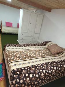 a bedroom with a bed with a dresser in the background at El Campito in Necochea