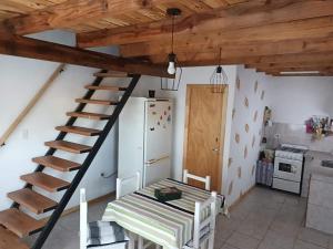 a kitchen with a staircase in a room with a refrigerator at El Campito in Necochea