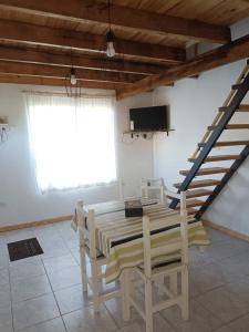 a dining room with a table and chairs and a staircase at El Campito in Necochea
