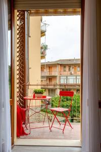 a red chair and a table on a balcony at Boutique Apartment Family in Chiusi