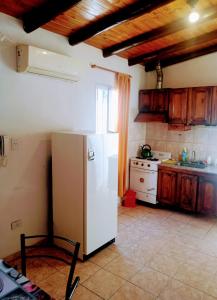 Il comprend une cuisine équipée d'un réfrigérateur blanc et d'une cuisinière. dans l'établissement Casas de Carlos en San Rafael Complejo coronel campos, à San Rafael