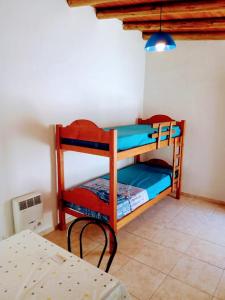 une chambre avec deux lits superposés et une table dans l'établissement Casas de Carlos en San Rafael Complejo coronel campos, à San Rafael