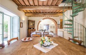 ein Esszimmer mit einem Holztisch mit Blumen darauf in der Unterkunft Cozy Home In Sarteano -Si- With Kitchen in Castiglioncello del Trinoro