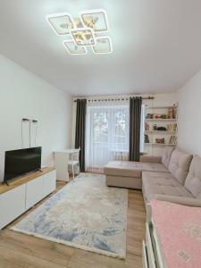 a living room with a couch and a television at Cozy apartment in the city center of Karakol in Karakol