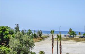 a road with palm trees and the ocean in the background at Pet Friendly Home In Nocera Terinese in Nocera Terinese