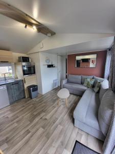 a living room with a couch and a table at Chalet tussen Zee en Meer in Lauwersoog +16 photos
