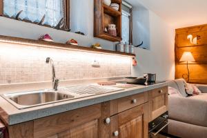 a kitchen with a sink and a couch at Maison de l'écureuil in Courmayeur +30 photos