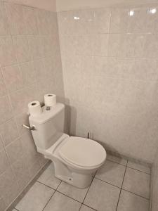 a bathroom with a toilet with two rolls of toilet paper on it at Chambre indépendante in Les Avenières