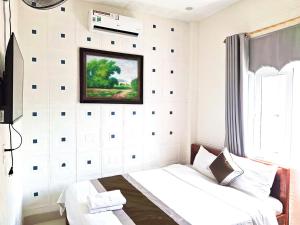 a bedroom with a bed and a picture on the wall at Khách sạn 68 ĐỒNG HẢI in Dong Hoi