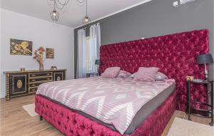 a bedroom with a large bed with a red headboard at 3 Bedroom Gorgeous Home In Jadrtovac in Jadrtovac