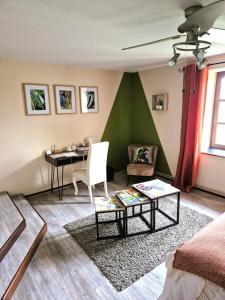 una sala de estar con una pared verde y una mesa. en Au Lavoir du Serein "La Billaude" et "La Langouette", en Saint-Germain-lès-Arlay
