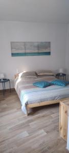 a bed in a white room with two tables at Casa Vacanze IL Primo Sole in Finale Ligure