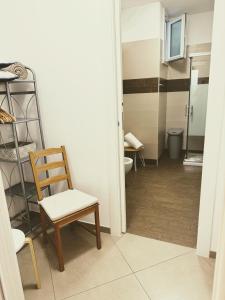 a room with a chair and a bathroom with a toilet at Alba b&b in Polignano a Mare