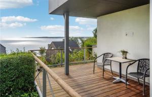 a balcony with a table and chairs and a view of the water at 3 Bedroom Lovely Home In Børkop in Børkop