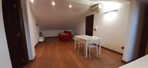 a dining room with a white table and a red chair at Casa Bella Apartment in San Giovanni Rotondo