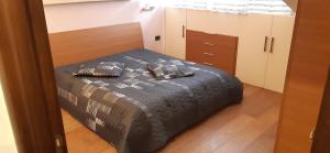 a bedroom with a bed with a black comforter at Casa Bella Apartment in San Giovanni Rotondo
