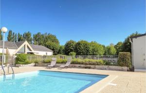 a swimming pool with two chairs and a fence at Beautiful Home In Montmartin-Sur-Mer in Montmartin-sur-Mer +13 photos