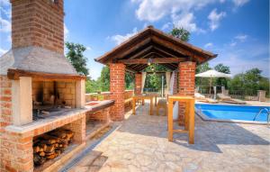 een bakstenen open haard naast een zwembad bij Villa Oxalis in Poreč