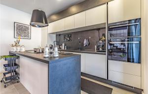 une cuisine avec des placards blancs et un îlot bleu dans l'établissement 3 Bedroom Awesome Home In Orbanici, à Orbanići