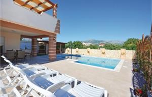 a patio with white chairs and a swimming pool at Gorgeous Home In Solin in Solin