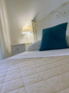 a bed with a blue pillow on top of it at Alba b&b in Polignano a Mare