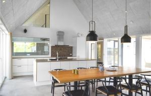a kitchen with a wooden table and some chairs at Lovely Home In Ringkøbing With Sauna in Ringkøbing