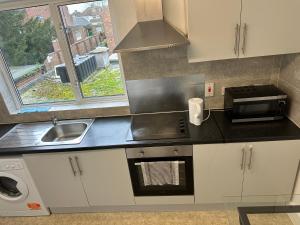 a kitchen with a sink and a microwave at Shouth Harrow in Harrow on the Hill