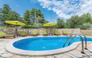 a swimming pool with patio furniture and umbrellas at Holiday Home Markovac 11 in Markovac