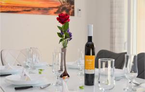 a bottle of wine sitting on a table with glasses at Cozy Home In Rovanjska in Rovanjska