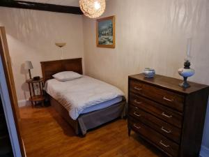 ein Schlafzimmer mit einem Bett und einer Kommode darin in der Unterkunft La Petite Maison Pa'Meuse in Monthermé