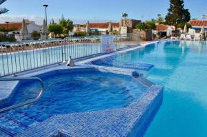 a large swimming pool with blue water at Happy scape bungalow with relaxing garden in San Bartolomé de Tirajana +16 photos