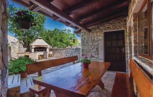 a wooden table and chairs on a patio with a house at Holiday Home Svetvincenat With Outdoor Swimming Pool 207 in Svetvinčenat